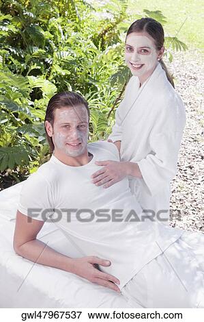 Couple smiling with facial masks on their faces View Large Photo Image Stock Photo - Couple smiling with facial masks on their faces. Fotosearch