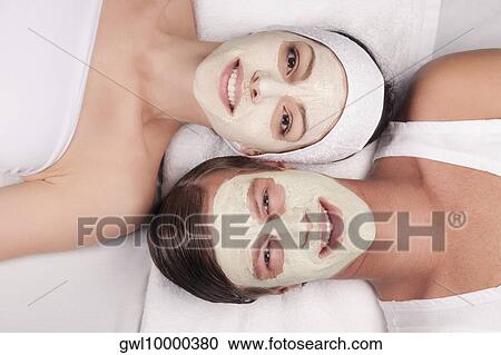 Stock Image - Couple with face pack on their faces. Fotosearch