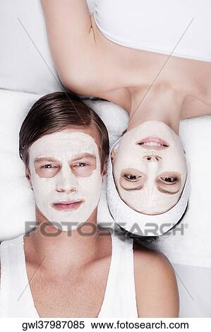 Stock Photography - Couple with face pack on their faces. Fotosearch