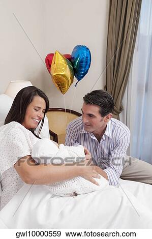 Couple with their newborn baby in a hospital View Large Photo Image Stock Photo - Couple with their newborn baby in a hospital. Fotosearch