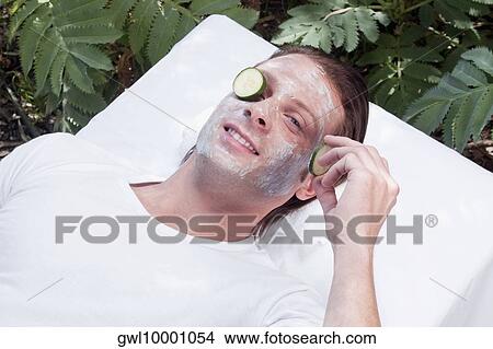 Picture - Cucumber slice on a man's eye. Fotosearch