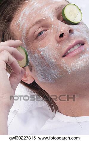 Stock Photography - Cucumber slice on a man's eye. Fotosearch