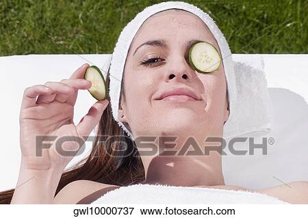 Stock Photo - Cucumber slice on a woman's eye. Fotosearch