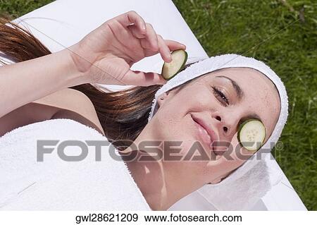 Cucumber slice on a woman's eye View Large Photo Image Stock Photo - Cucumber slice on a woman's eye. Fotosearch