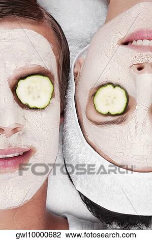 Cucumber slices on a couple's eyes View Large Photo Image Stock Image - Cucumber slices on a couple's eyes. Fotosearch