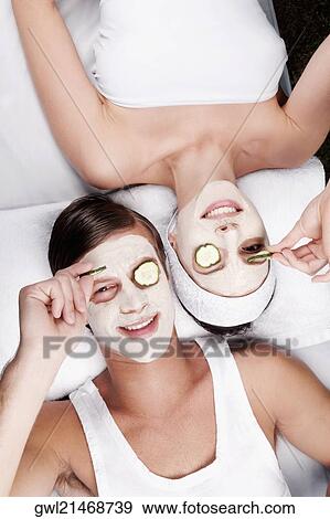 Cucumber slices on a couple's eyes View Large Photo Image Stock Photo - Cucumber slices on a couple's eyes. Fotosearch