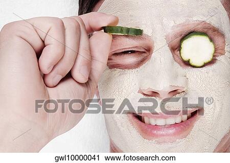 Stock Image - Cucumber slices on a man's eyes. Fotosearch