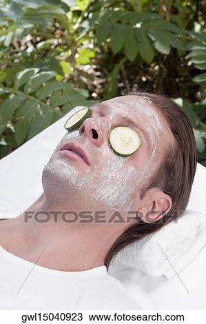 Cucumber slices on a man's eyes View Large Photo Image Stock Image - Cucumber slices on a man's eyes. Fotosearch