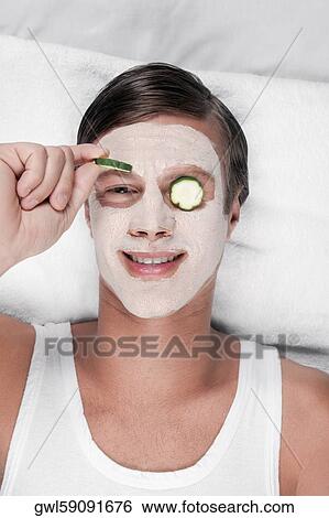 Cucumber slices on a man's eyes View Large Photo Image Stock Photograph - Cucumber slices on a man's eyes. Fotosearch