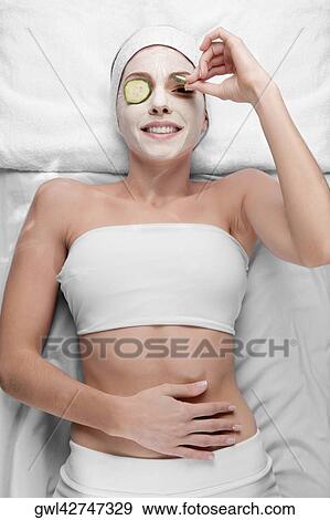Cucumber slices on a woman's eyes View Large Photo Image Stock Photo - Cucumber slices on a woman's eyes. Fotosearch