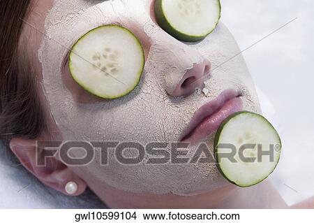 Cucumber slices on a woman's face View Large Photo Image Picture - Cucumber slices on a woman's face. Fotosearch