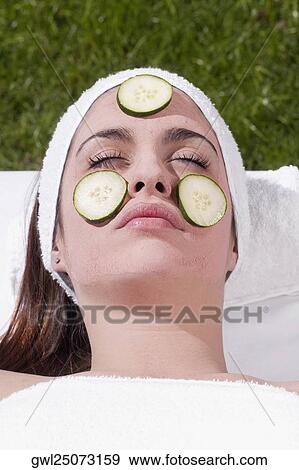 Cucumber slices on a woman's face View Large Photo Image Stock Photo - Cucumber slices on a woman's face. Fotosearch
