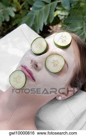 Cucumber slices on a woman's face View Large Photo Image Stock Photograph - Cucumber slices on a woman's face. Fotosearch