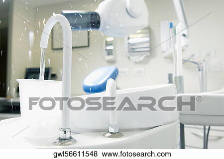 Dental cuspidor with a cup in an examination room View Large Photo Image Stock Photo - Dental cuspidor with a cup in an examination room. Fotosearch