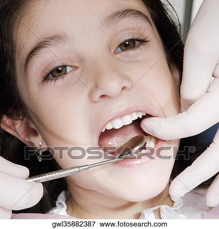 Dentist checking girl's teeth View Large Photo Image Stock Photo - Dentist checking girl's teeth. Fotosearch