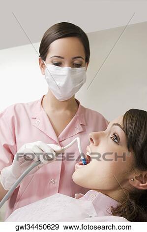Dentist cleaning woman's teeth View Large Photo Image Stock Photo - Dentist cleaning woman's teeth. Fotosearch
