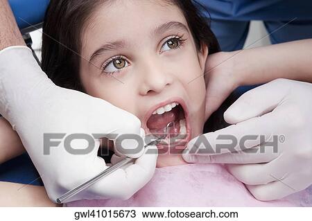 Dentist examining a girl's teeth View Large Photo Image Stock Image - Dentist examining a girl's teeth. Fotosearch