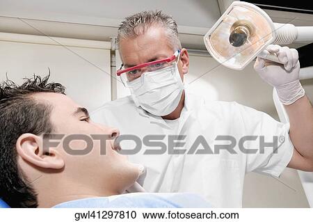Stock Image - Dentist examining a patient. Fotosearch