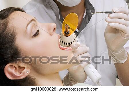 Dentist examining a woman's teeth View Large Photo Image Stock Photo - Dentist examining a woman's teeth. Fotosearch