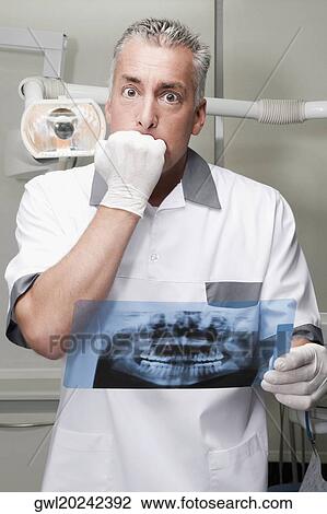 Dentist examining an X-Ray report View Large Photo Image Stock Image - Dentist examining an X-Ray report. Fotosearch