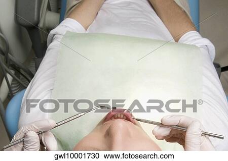 Dentist examining man's teeth View Large Photo Image Stock Image - Dentist examining man's teeth. Fotosearch