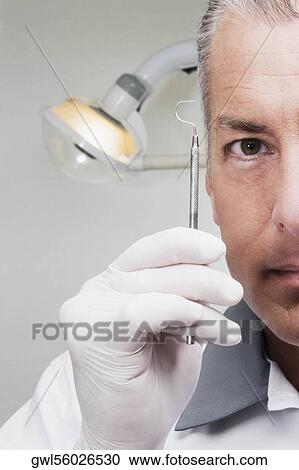 Dentist holding a dental scaler View Large Photo Image Stock Image - Dentist holding a dental scaler. Fotosearch