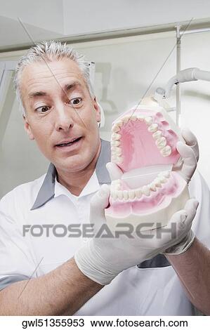 Dentist holding a set of dentures View Large Photo Image Stock Image - Dentist holding a set of dentures. Fotosearch