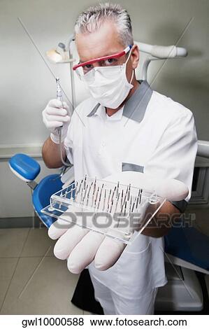 Stock Photo - Dentist holding dental drill bits. Fotosearch