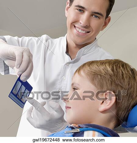 Dentist showing an X-Ray report to a boy View Large Photo Image Stock Photo - Dentist showing an X-Ray report to a boy. Fotosearch