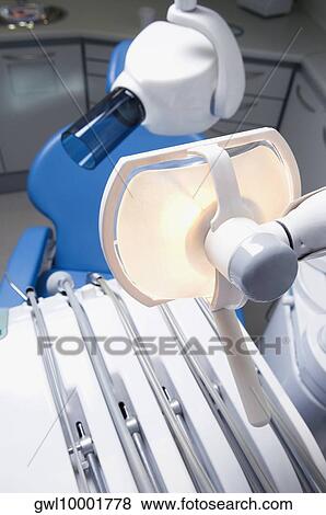 Dentist's chair with dental equipments in an examination room View Large Photo Image Stock Photo - Dentist's chair with dental equipments in an examination room. Fotosearch