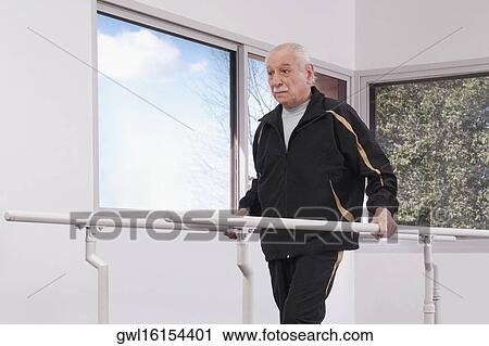 Disabled man practicing on a walker View Large Photo Image Stock Image - Disabled man practicing on a walker. Fotosearch