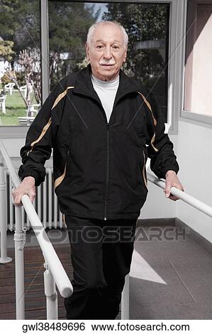 Disabled man practicing on a walker View Large Photo Image Stock Photograph - Disabled man practicing on a walker. Fotosearch