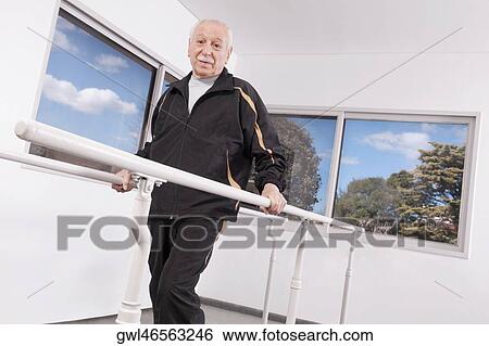 Disabled man practicing on a walker View Large Photo Image Stock Photograph - Disabled man practicing on a walker. Fotosearch