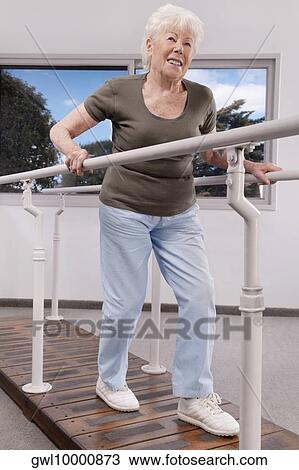 Disabled woman practicing on a walker View Large Photo Image Stock Image - Disabled woman practicing on a walker. Fotosearch