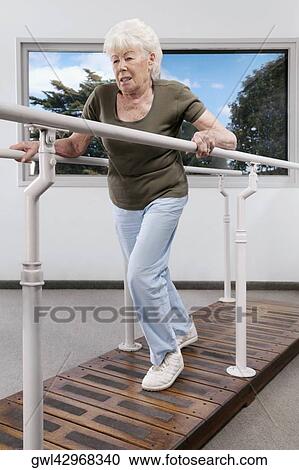 Stock Image - Disabled woman practicing on a walker. Fotosearch