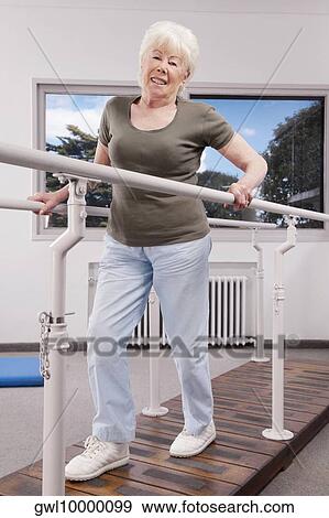 Disabled woman practicing on a walker View Large Photo Image Stock Photo - Disabled woman practicing on a walker. Fotosearch