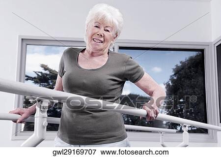 Disabled woman practicing on a walker View Large Photo Image Stock Photo - Disabled woman practicing on a walker. Fotosearch