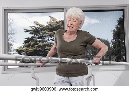 Disabled woman practicing on a walker View Large Photo Image Stock Photograph - Disabled woman practicing on a walker. Fotosearch