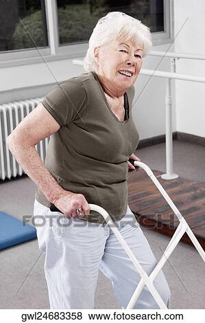 Disabled woman walking with a walker View Large Photo Image Stock Photo - Disabled woman walking with a walker. Fotosearch