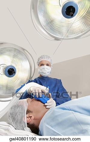 Doctor anaesthetizing a patient in an operating room View Large Photo Image Stock Image - Doctor anaesthetizing a patient in an operating room. Fotosearch