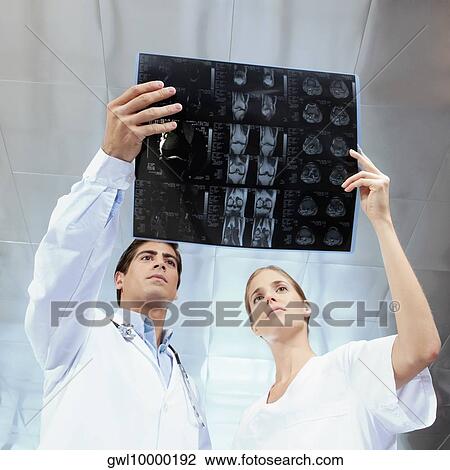Doctor and a female nurse examining an x-ray report View Large Photo Image Stock Image - Doctor and a female nurse examining an x-ray report. Fotosearch