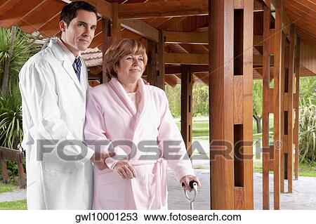 Doctor assisting a patient in walking in a rehabilitation centre View Large Photo Image Stock Image - Doctor assisting a patient in walking in a rehabilitation centre. Fotosearch
