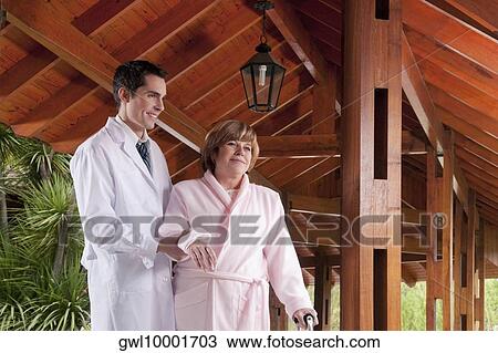 Doctor assisting a patient in walking in a rehabilitation centre View Large Photo Image Stock Image - Doctor assisting a patient in walking in a rehabilitation centre. Fotosearch