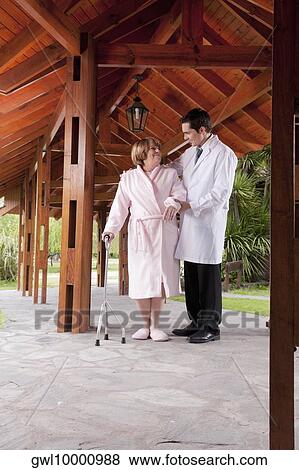 Doctor assisting a patient in walking in a rehabilitation centre View Large Photo Image Stock Photo - Doctor assisting a patient in walking in a rehabilitation centre. Fotosearch
