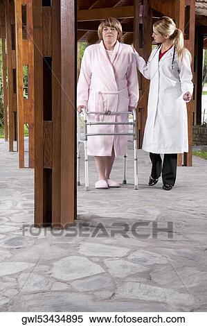 Stock Photography - Doctor assisting a patient in walking in a rehabilitation centre. Fotosearch