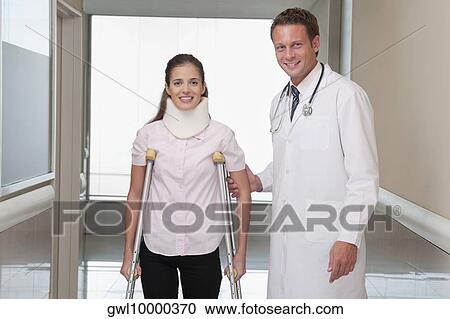 Doctor assisting a patient to walk in a hospital corridor View Large Photo Image Stock Image - Doctor assisting a patient to walk in a hospital corridor. Fotosearch
