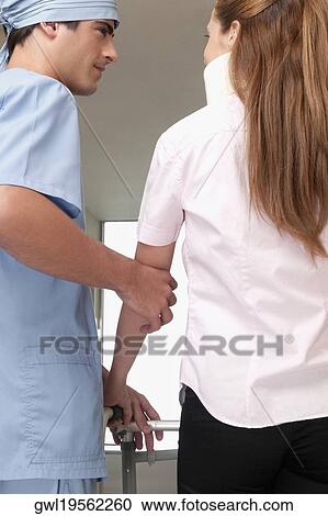 Doctor assisting a patient to walk in a hospital corridor View Large Photo Image Stock Image - Doctor assisting a patient to walk in a hospital corridor. Fotosearch