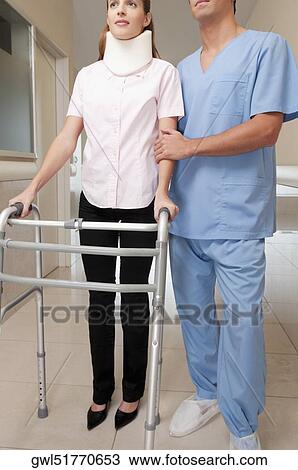 Doctor assisting a patient to walk in a hospital corridor View Large Photo Image Stock Image - Doctor assisting a patient to walk in a hospital corridor. Fotosearch