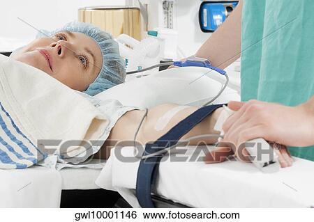 Stock Photograph - Doctor attaching pulse oxymeter to a patient's finger. Fotosearch