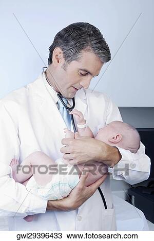 Doctor carrying a newborn baby View Large Photo Image Stock Image - Doctor carrying a newborn baby. Fotosearch